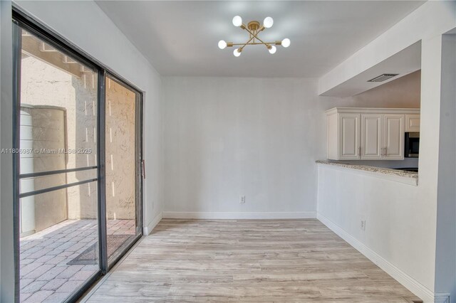 8015 SW 21st Ct, Davie, FL 33324 - unfurnished dining area featuring a chandelier, light wood-style floors, and baseboards