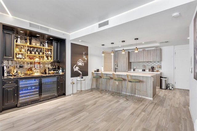 801 S Miami Ave Unit 3510, Miami, FL 33130 - indoor wet bar with decorative backsplash, light wood-style flooring, wine cooler, decorative light fixtures, and a raised ceiling