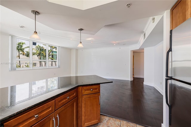 2000 N Bayshore Dr Unit 228, Miami, FL 33137 - kitchen featuring freestanding refrigerator, brown cabinets, dark stone countertops, and pendant lighting