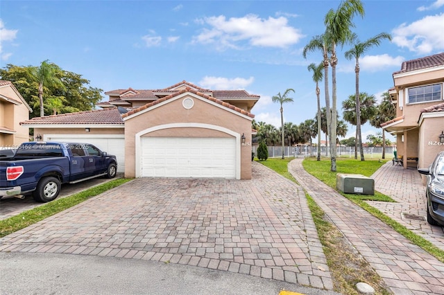 8252 NW 191st Ln Unit 15R, Hialeah, FL 33015 - view of front of property featuring a tile roof, a garage, stucco siding, and decorative driveway