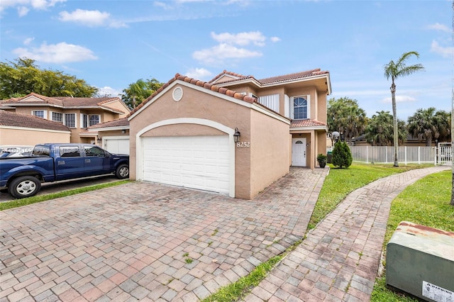 8252 NW 191st Ln Unit 15R, Hialeah, FL 33015 - view of front of property featuring a tiled roof, stucco siding, a garage, and decorative driveway