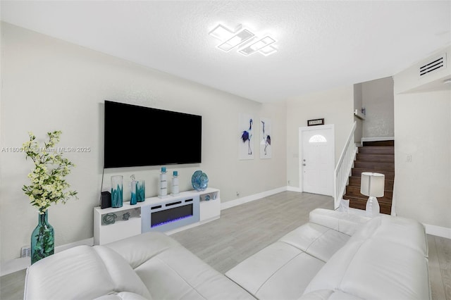 8252 NW 191st Ln Unit 15R, Hialeah, FL 33015 - living area featuring stairs, light wood finished floors, a textured ceiling, and baseboards