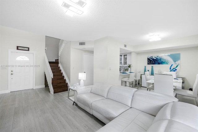 8252 NW 191st Ln Unit 15R, Hialeah, FL 33015 - living room featuring stairway, wood finished floors, a textured ceiling, and baseboards
