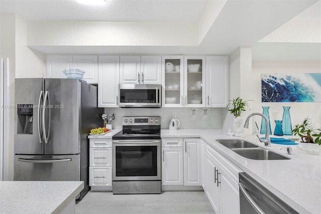 8252 NW 191st Ln Unit 15R, Hialeah, FL 33015 - kitchen featuring stainless steel appliances, a sink, white cabinets, glass insert cabinets, and light stone countertops