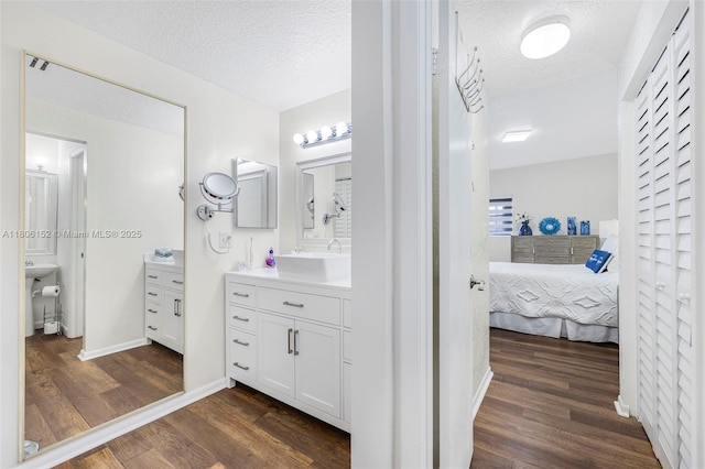 8252 NW 191st Ln Unit 15R, Hialeah, FL 33015 - ensuite bathroom featuring wood finished floors, a textured ceiling, and vanity