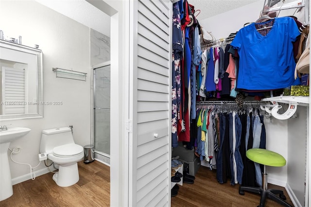 8252 NW 191st Ln Unit 15R, Hialeah, FL 33015 - bathroom with wood finished floors, toilet, a stall shower, baseboards, and a textured ceiling