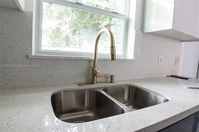 4110 SW 32nd Ct, West Park, FL 33023 - kitchen view of decorative backsplash, light stone countertops, and white cabinetry