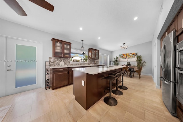 6847 NW 24th Way, Fort Lauderdale, FL 33309 - kitchen with freestanding refrigerator, a kitchen bar, light countertops, tasteful backsplash, and glass insert cabinets