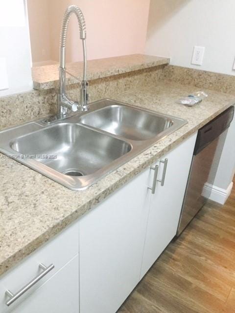 927 Riverside Dr Unit 326, Coral Springs, FL 33071 - kitchen view of a sink, white cabinetry, light wood finished floors, and light countertops