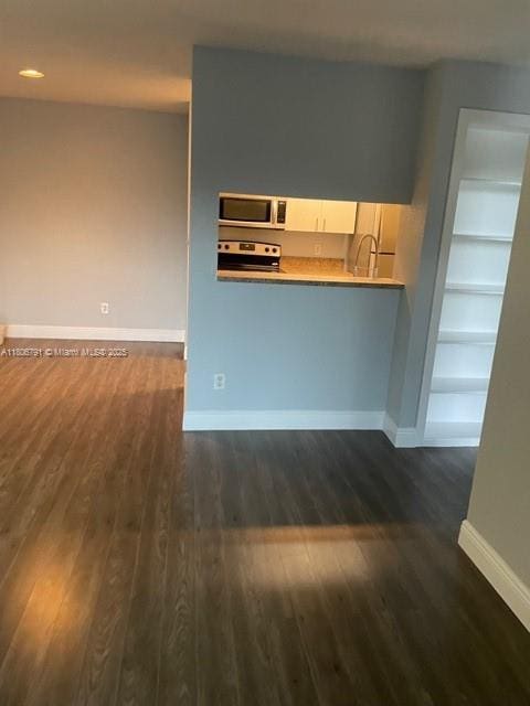 927 Riverside Dr Unit 326, Coral Springs, FL 33071 - kitchen featuring stainless steel appliances, baseboards, dark wood-style floors, built in features, and white cabinets