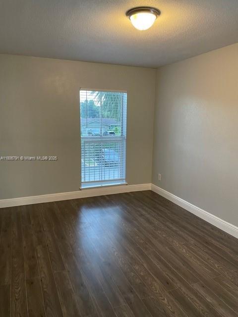 927 Riverside Dr Unit 326, Coral Springs, FL 33071 - unfurnished room featuring dark wood-style floors and baseboards