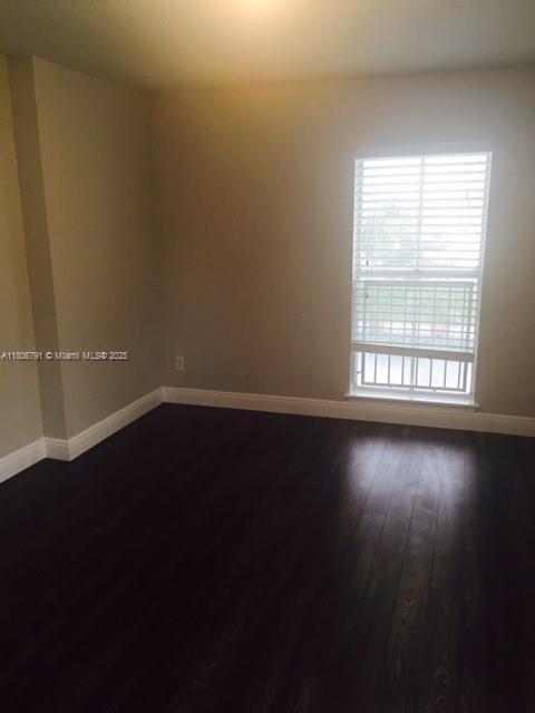 927 Riverside Dr Unit 326, Coral Springs, FL 33071 - unfurnished room featuring baseboards and dark wood-style flooring