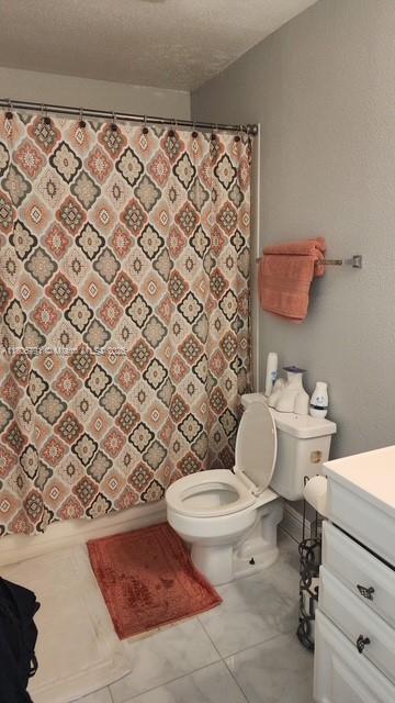 927 Riverside Dr Unit 326, Coral Springs, FL 33071 - bathroom featuring toilet, vanity, a textured ceiling, and curtained shower