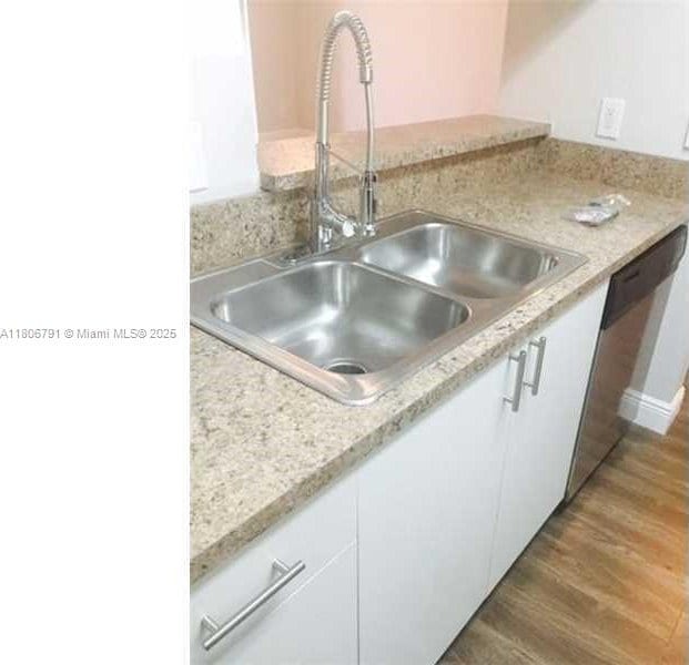 927 Riverside Dr Unit 326, Coral Springs, FL 33071 - kitchen featuring a sink, white cabinets, light countertops, wood finished floors, and stainless steel dishwasher