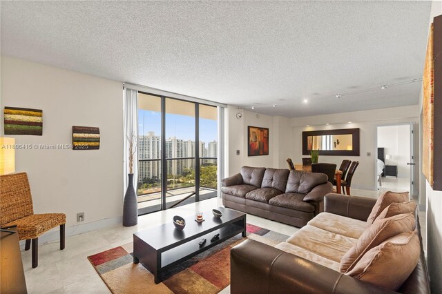 18181 NE 31st Ct Unit Ph07, Aventura, FL 33160 - living room featuring expansive windows, a textured ceiling, and baseboards