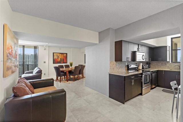 18181 NE 31st Ct Unit Ph07, Aventura, FL 33160 - kitchen featuring stainless steel electric range, open floor plan, decorative backsplash, a sink, and light stone countertops