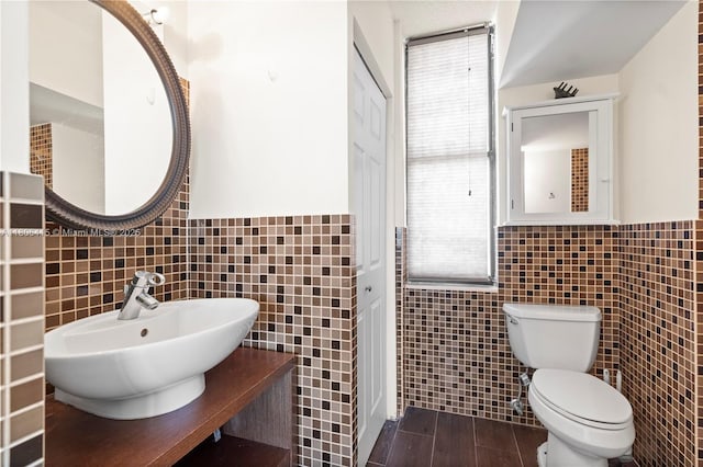 18181 NE 31st Ct Unit Ph07, Aventura, FL 33160 - bathroom with tile walls, a sink, toilet, and wainscoting
