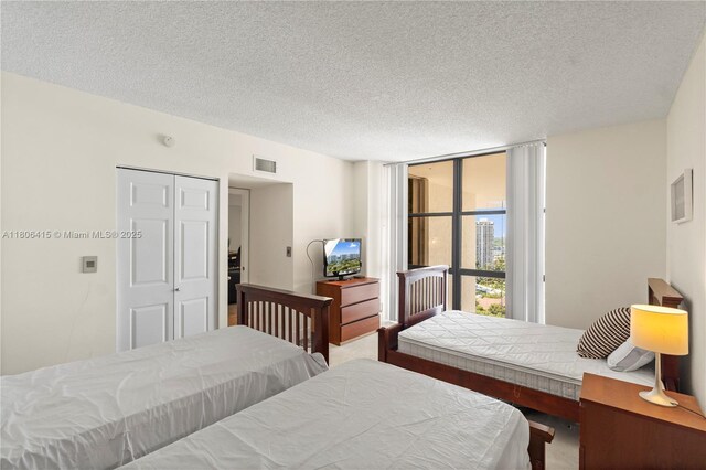 18181 NE 31st Ct Unit Ph07, Aventura, FL 33160 - carpeted bedroom with a wall of windows, a textured ceiling, and a closet