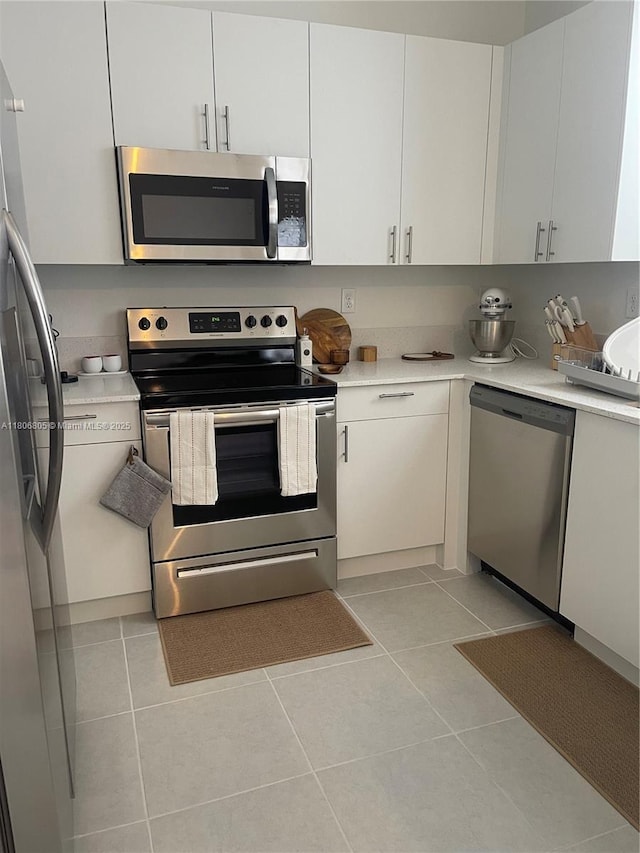 28577 SW 134th Ct, Homestead, FL 33033 - kitchen with stainless steel appliances, light countertops, light tile patterned floors, and white cabinets