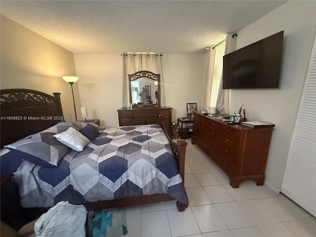 12209 SW 14th Ln Unit 1101, Miami, FL 33184 - bedroom with light tile patterned flooring and a textured ceiling