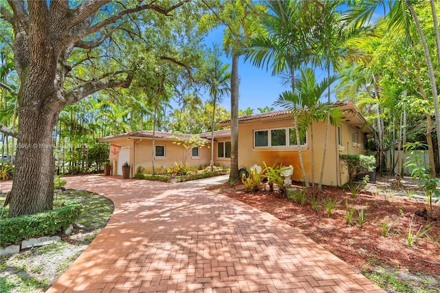 1090 Meadowlark Ave, Miami Springs, FL 33166 - view of front of house with decorative driveway, stucco siding, and a garage
