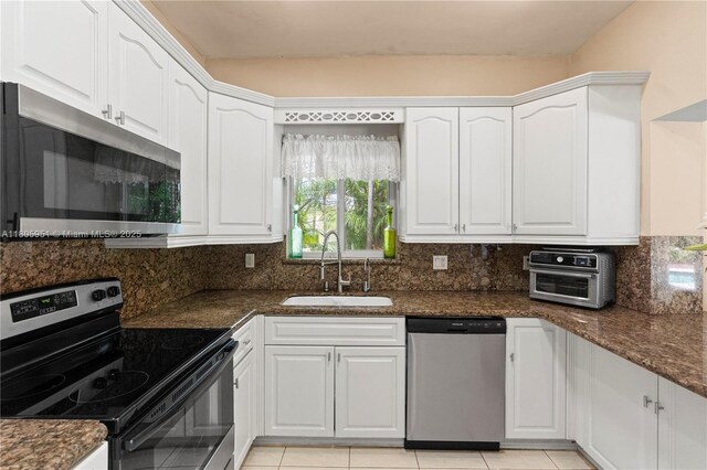 1090 Meadowlark Ave, Miami Springs, FL 33166 - kitchen with appliances with stainless steel finishes, white cabinets, backsplash, and light tile patterned floors