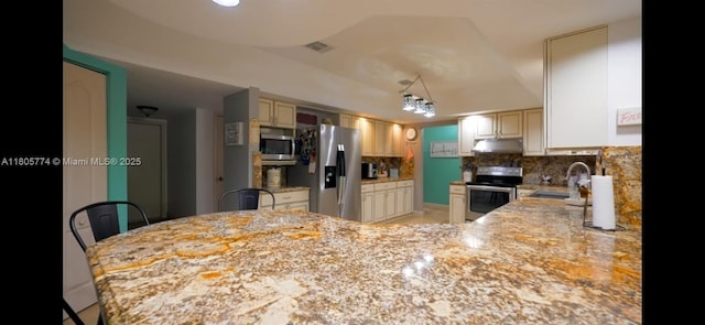 15225 SW 235th St, Homestead, FL 33032 - kitchen with appliances with stainless steel finishes, a sink, tasteful backsplash, under cabinet range hood, and cream cabinetry