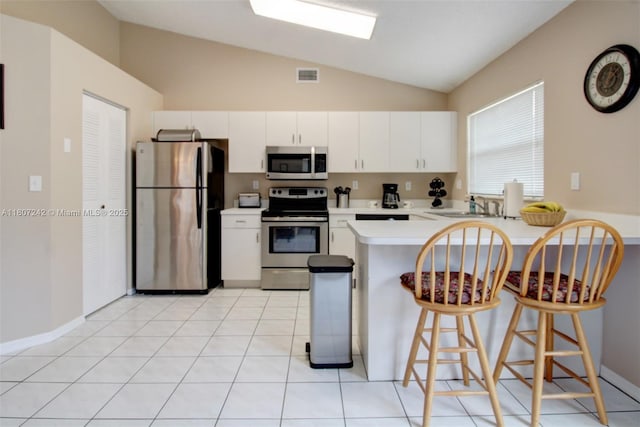 19171 NW 89th Ct, Hialeah, FL 33018 - kitchen with stainless steel appliances, vaulted ceiling, a peninsula, light countertops, and a sink