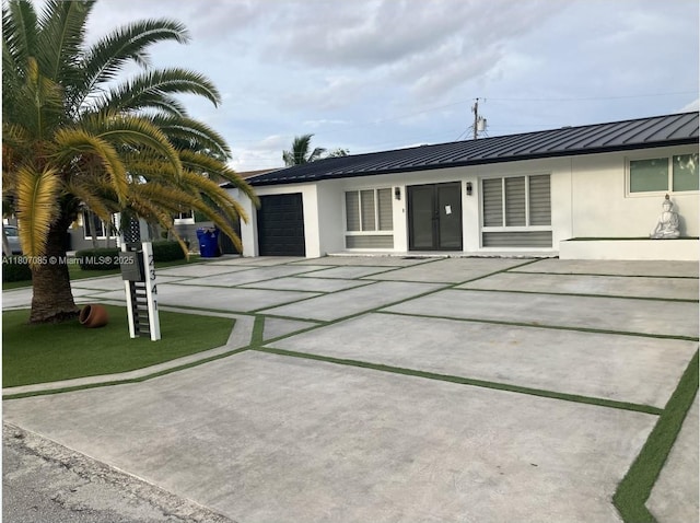 2341 Tarpon Dr, Miramar, FL 33023 - view of front facade with stucco siding, an attached garage, concrete driveway, a standing seam roof, and metal roof