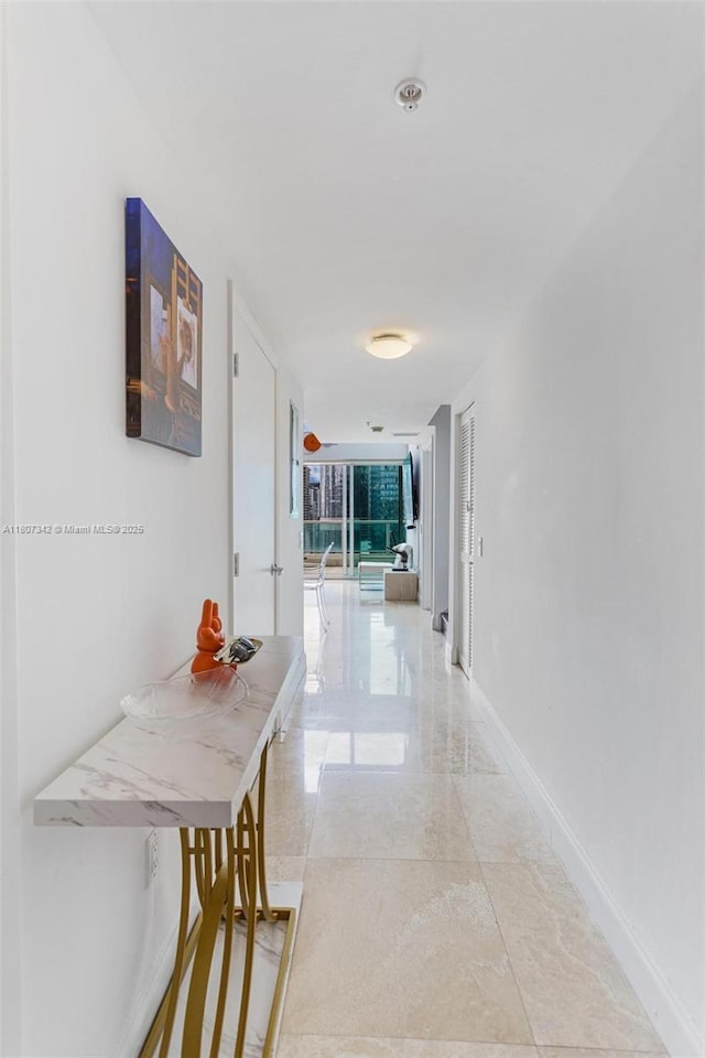 41 SE 5th St Unit 2008, Miami, FL 33131 - corridor featuring baseboards, light marble finish floors, and a wall of windows