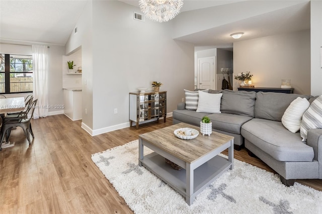 15828 S Ashby Field Rd S, Davie, FL 33331 - living room featuring lofted ceiling, a chandelier, light wood-style flooring, and baseboards