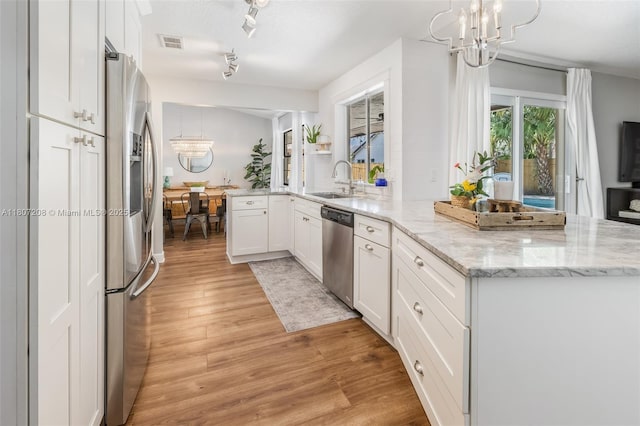 15828 S Ashby Field Rd S, Davie, FL 33331 - kitchen with a chandelier, a peninsula, appliances with stainless steel finishes, and white cabinetry