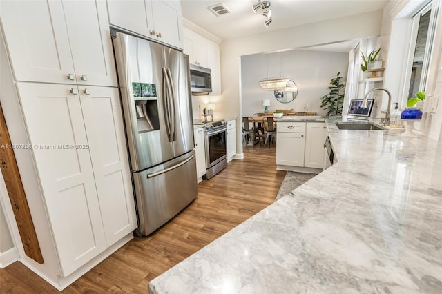 15828 S Ashby Field Rd S, Davie, FL 33331 - kitchen with stainless steel appliances, a sink, white cabinets, and light stone counters