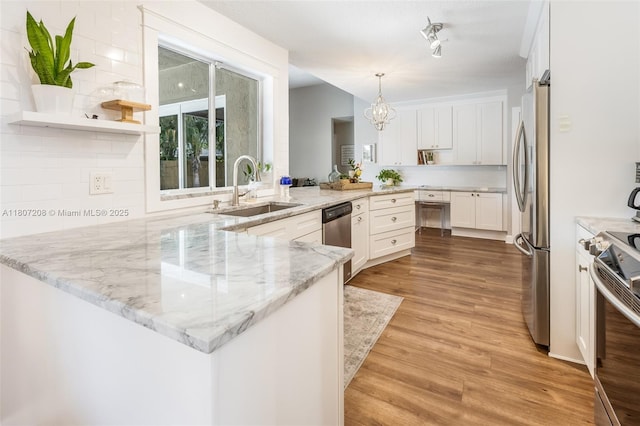 15828 S Ashby Field Rd S, Davie, FL 33331 - kitchen with a sink, appliances with stainless steel finishes, a peninsula, white cabinets, and light wood-style floors