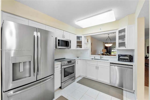 6080 Huntwick Ter Unit 202, Delray Beach, FL 33484 - kitchen with stainless steel appliances, a sink, light countertops, white cabinetry, and a textured ceiling