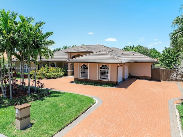 8281 SW 84th Ter, Miami, FL 33143 - view of front of home featuring a garage, decorative driveway, a tile roof, and stucco siding