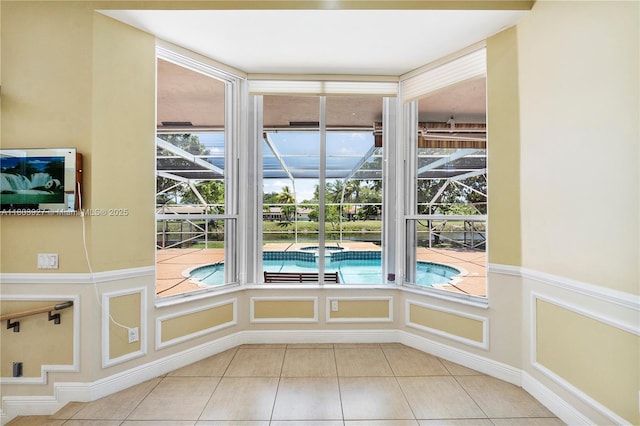 8281 SW 84th Ter, Miami, FL 33143 - unfurnished room featuring light tile patterned flooring, a sunroom, a decorative wall, and a wainscoted wall