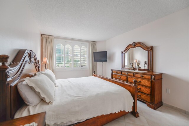 1950 S Ocean Dr Unit 3L, Hallandale Beach, FL 33009 - bedroom with a textured ceiling, baseboards, and light tile patterned floors