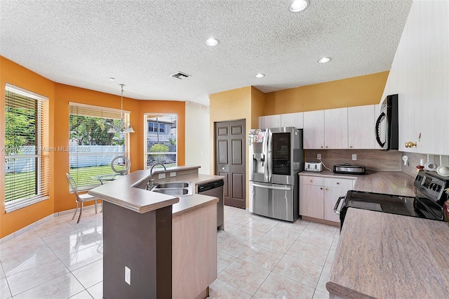 17933 SW 33rd Ct, Miramar, FL 33029 - kitchen featuring black appliances, a sink, an island with sink, a textured ceiling, and decorative backsplash