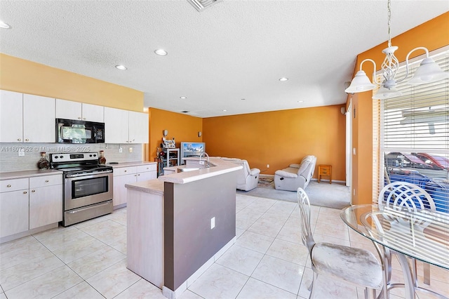 17933 SW 33rd Ct, Miramar, FL 33029 - kitchen with black microwave, stainless steel range with electric cooktop, light countertops, open floor plan, and recessed lighting