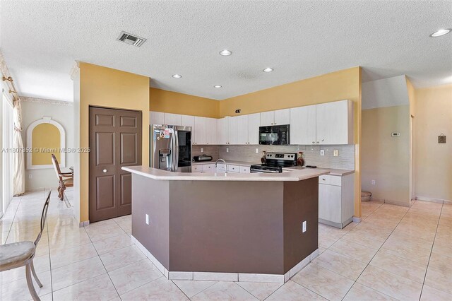17933 SW 33rd Ct, Miramar, FL 33029 - kitchen featuring stainless steel appliances, light countertops, a kitchen island with sink, decorative backsplash, and light tile patterned floors