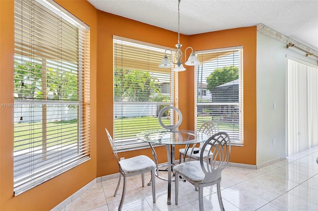 17933 SW 33rd Ct, Miramar, FL 33029 - dining area featuring a chandelier, a textured ceiling, healthy amount of natural light, light tile patterned floors, and baseboards