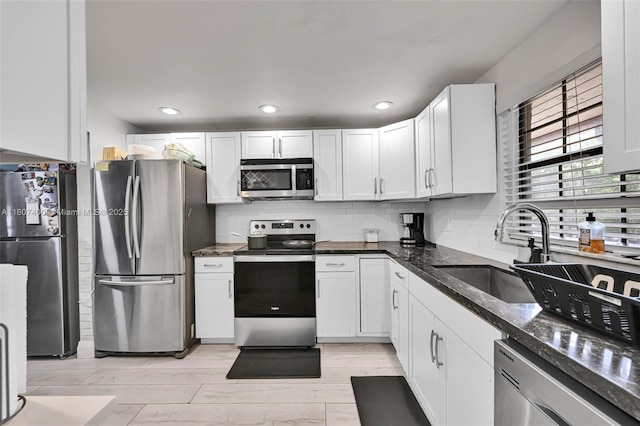 3361 NW 85th Ave Unit 305, Coral Springs, FL 33065 - kitchen with appliances with stainless steel finishes, a sink, backsplash, dark stone countertops, and white cabinets