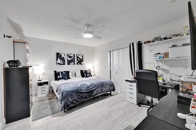 3361 NW 85th Ave Unit 305, Coral Springs, FL 33065 - bedroom with light wood-type flooring, an office area, a textured ceiling, and a ceiling fan