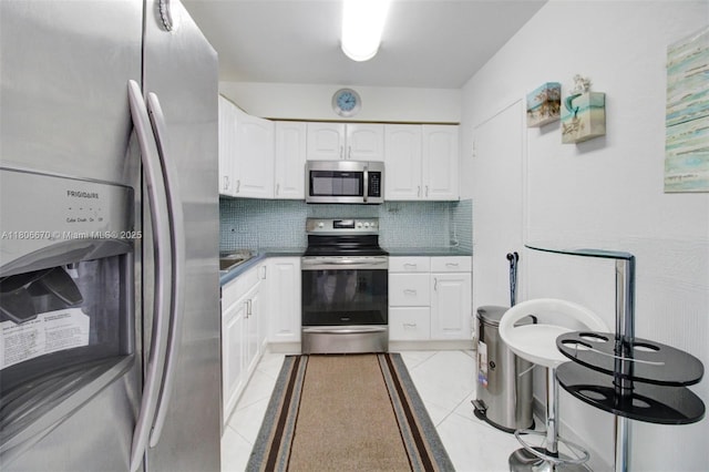 1965 S Ocean Dr Unit Mq, Hallandale Beach, FL 33009 - kitchen with stainless steel appliances, backsplash, white cabinetry, and light tile patterned flooring