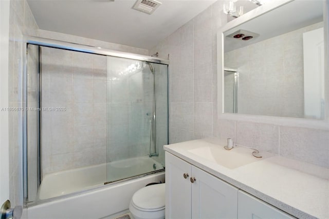 1965 S Ocean Dr Unit Mq, Hallandale Beach, FL 33009 - bathroom with tile walls, vanity, toilet, bath / shower combo with glass door, and tasteful backsplash