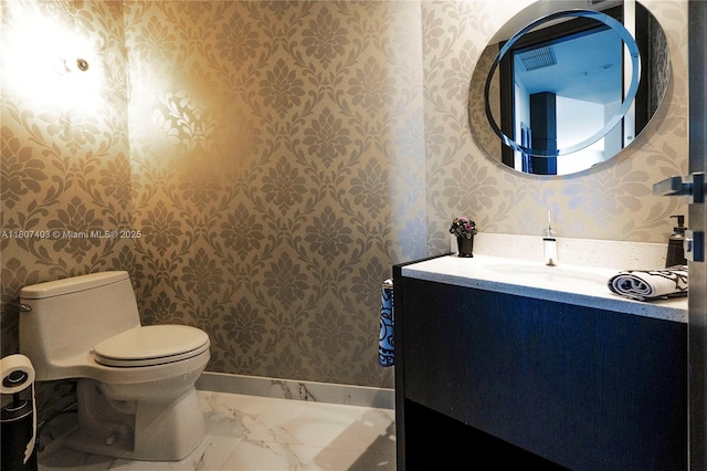 18201 Collins Ave Unit 3909, Sunny Isles Beach, FL 33160 - bathroom featuring wallpapered walls, toilet, vanity, marble finish floors, and baseboards