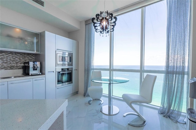 18201 Collins Ave Unit 3909, Sunny Isles Beach, FL 33160 - dining space with a chandelier, light marble finish floors, and a water view