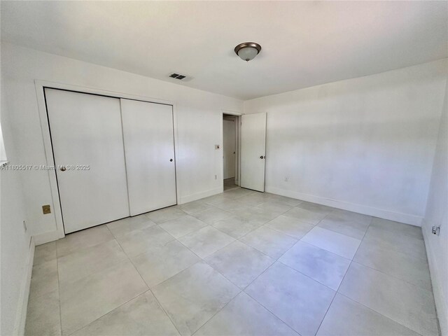 8890 SW 155th Ter, Palmetto Bay, FL 33157 - unfurnished bedroom with baseboards, a closet, and light tile patterned flooring