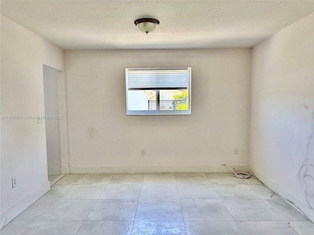 8890 SW 155th Ter, Palmetto Bay, FL 33157 - empty room featuring a textured ceiling, baseboards, and light tile patterned flooring